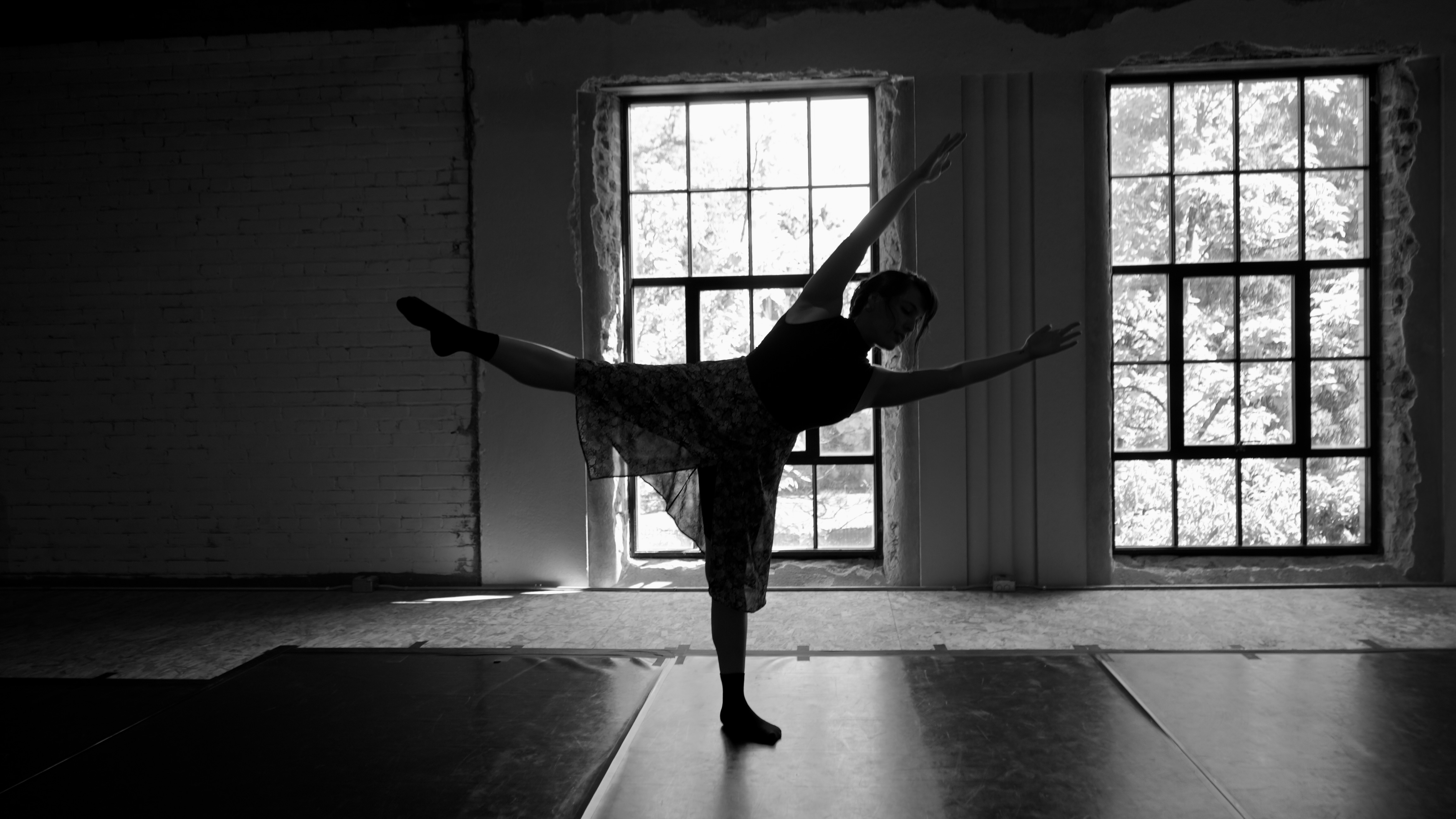 Silhouette of a ballerina in a Roman Army Parade Twistposition against a window backdrop.